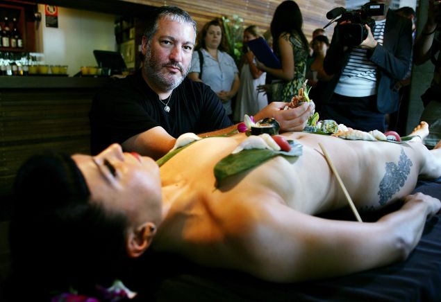 SYDNEY, AUSTRALIA - FEBRUARY 23: New York artist Spencer Tunick poses whilst standing over a model dressed only with sushi aT a press conference at the Toko Restaurant & Bar on February 23, 2010 in Sydney, Australia. Tunick will be creating his next installation 'The Base' on the steps of the Sydney Opera House as part of the 32nd Sydney Mardi Gras Festival.