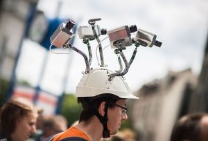 Chairman of Hesse's Pirate Party Volker Berkhout wears a hat with mock surveillance cameras during a demonstration against spying activities of the US intelligence agency NSA and its German partner service BND in Frankfurt am Main, central Germany, on May 30, 2015.
