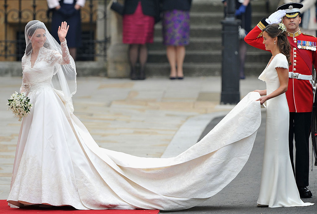 LONDON, ENGLAND - APRIL 29: Catherine Middleton waves to the crowds as her sister and Maid of Honour Pippa Middleton holds her dress before walking in to the Abbey to attend the Royal Wedding of Prince William to Catherine Middleton at Westminster Abbey on April 29, 2011 in London, England. The marriage of the second in line to the British throne is to be led by the Archbishop of Canterbury and will be attended by 1900 guests, including foreign Royal family members and heads of state. Thousands of well-wishers from around the world have also flocked to London to witness the spectacle and pageantry of the Royal Wedding. (Photo by Pascal Le Segretain/Getty Images)
