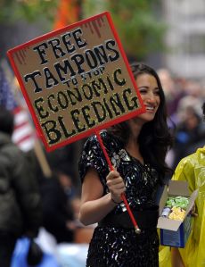 A woman hands out tampons to demonstrators with 'Occupy Wall Street' protest at Zuccotti Park in New York before they start cleaning up their belongings October 13, 2011 the morning after Mayor Bloomberg gave a message to Occupy Wall Street protestors that the park needs to be cleaned. Protestors, signs, and sleeping bags need to temporarily vacate the premises while the park's property owner can go in with a cleaning crew starting Friday.