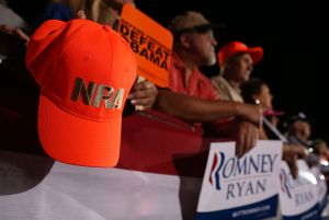 FISHERSVILLE, VA - OCTOBER 04: A supporter of Republican presidential candidate, former Massachusetts Gov. Mitt Romney and his running mate Rep Paul Ryan (R-WI) holds a National Rifle Association hat during a campaign rally at the Augusta Expoland on October 4, 2012 in Fishersville, Virginia. One day after the first Presidential debate, Mitt Romney spoke to the CPAC before heading to Virginia to campaign with his running mate Rep Paul Ryan (R-WI).