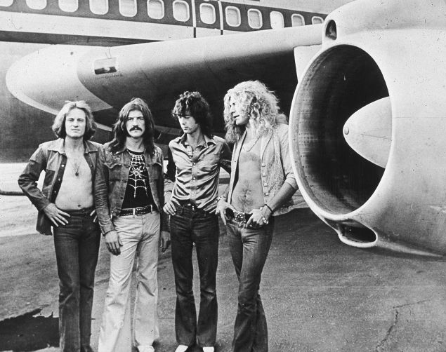 British rock band Led Zeppelin, (left - right): John Paul Jones, John Bonham (1948 - 1980), Jimmy Page and Robert Plant, pose in front of an their private airliner The Starship, 1973. 