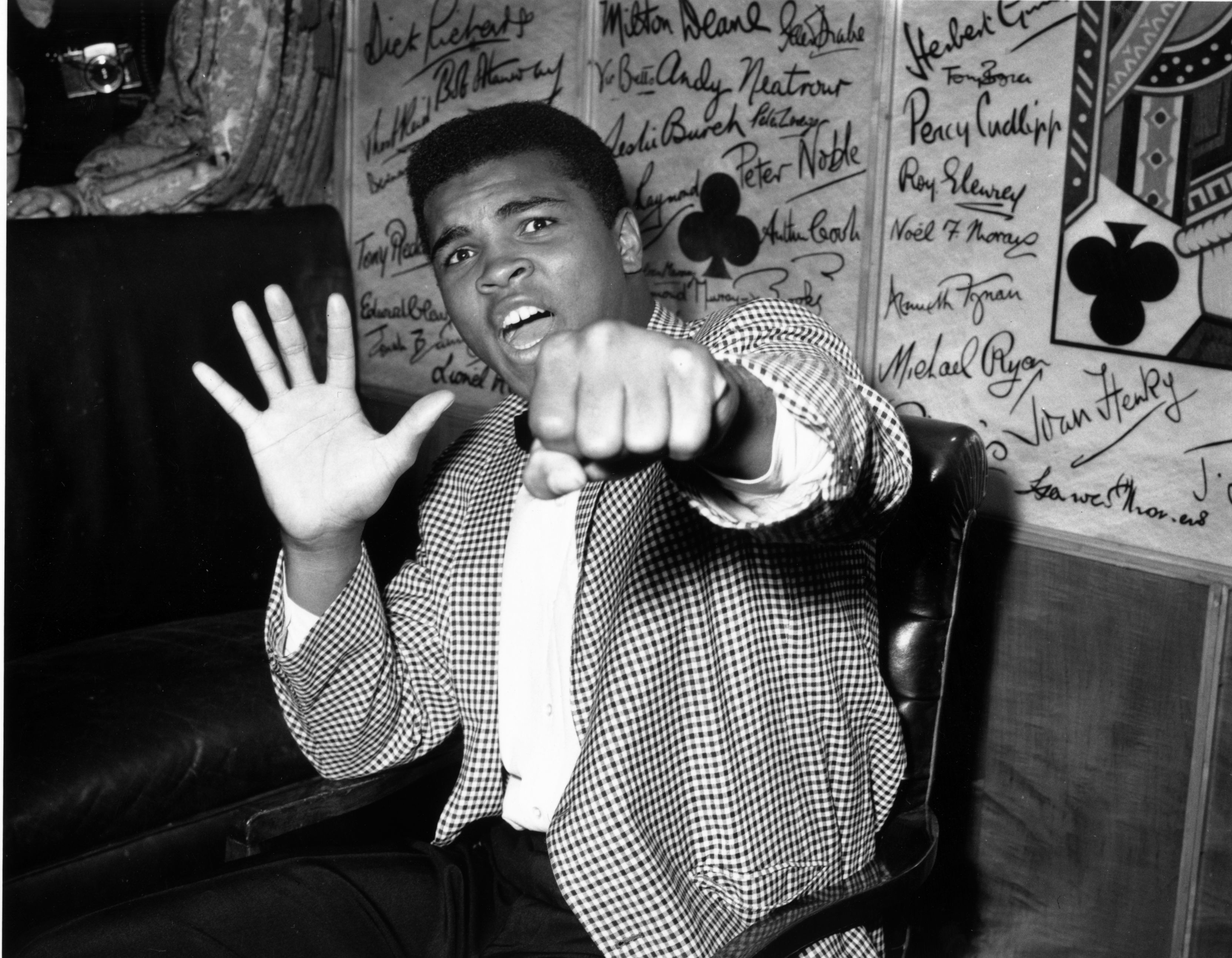 27th May 1963:  Supremely confident American boxer Cassius Clay holds up five fingers in a prediction of how many rounds it will take him to knock out British boxer Henry Cooper.  