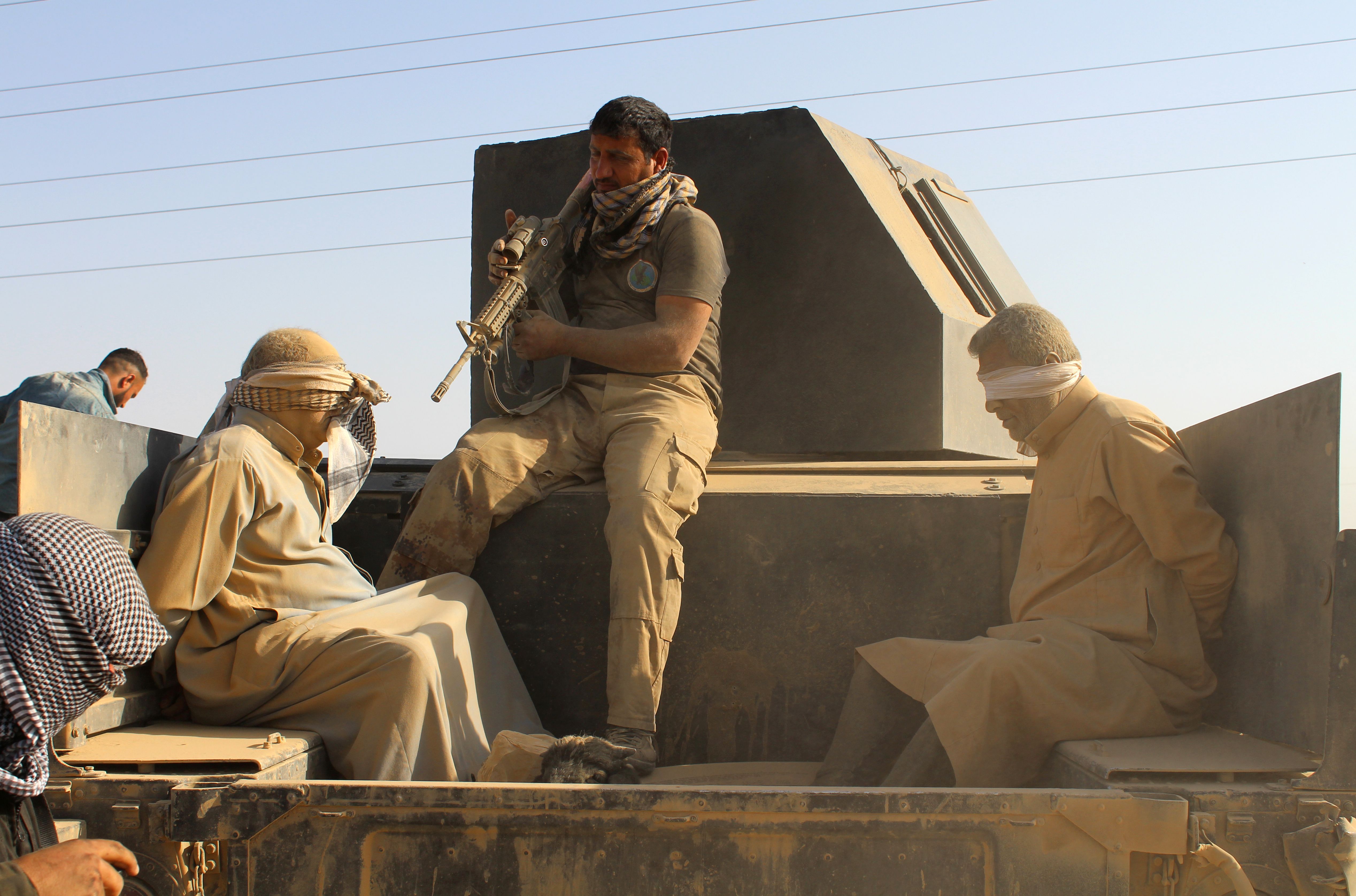 Iraqi government and counter-terrorism forces arrest men suspected of belonging to the Islamic State (IS) jihadist group on March 10, 2016 following an operation to retake the town of Zankura, northwest of Ramadi, in Anbar province, from IS. Iraqi forces retook a town from the Islamic State jihadist group in Anbar province Thursday and evacuated 10,000 civilians as they advanced up the Euphrates valley, a security spokesman said. The sprawling province of Anbar -- which borders Syria, Jordan and Saudi Arabia -- was at the heart of the "caliphate" that IS proclaimed in 2014. The jihadist group still holds most of the province but the noose is tightening around some of its key bastions. / AFP / MOADH AL-DULAIMI