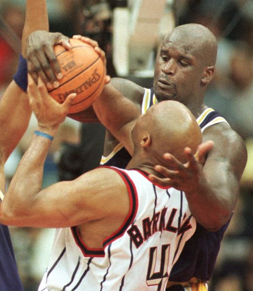 Shaquille O'Neal of the Los Angeles Lakers (back) stuffs Charles Barkley of the Houston Rockets during late action at Compaq Center 1 May 1999 in Houston, Texas.