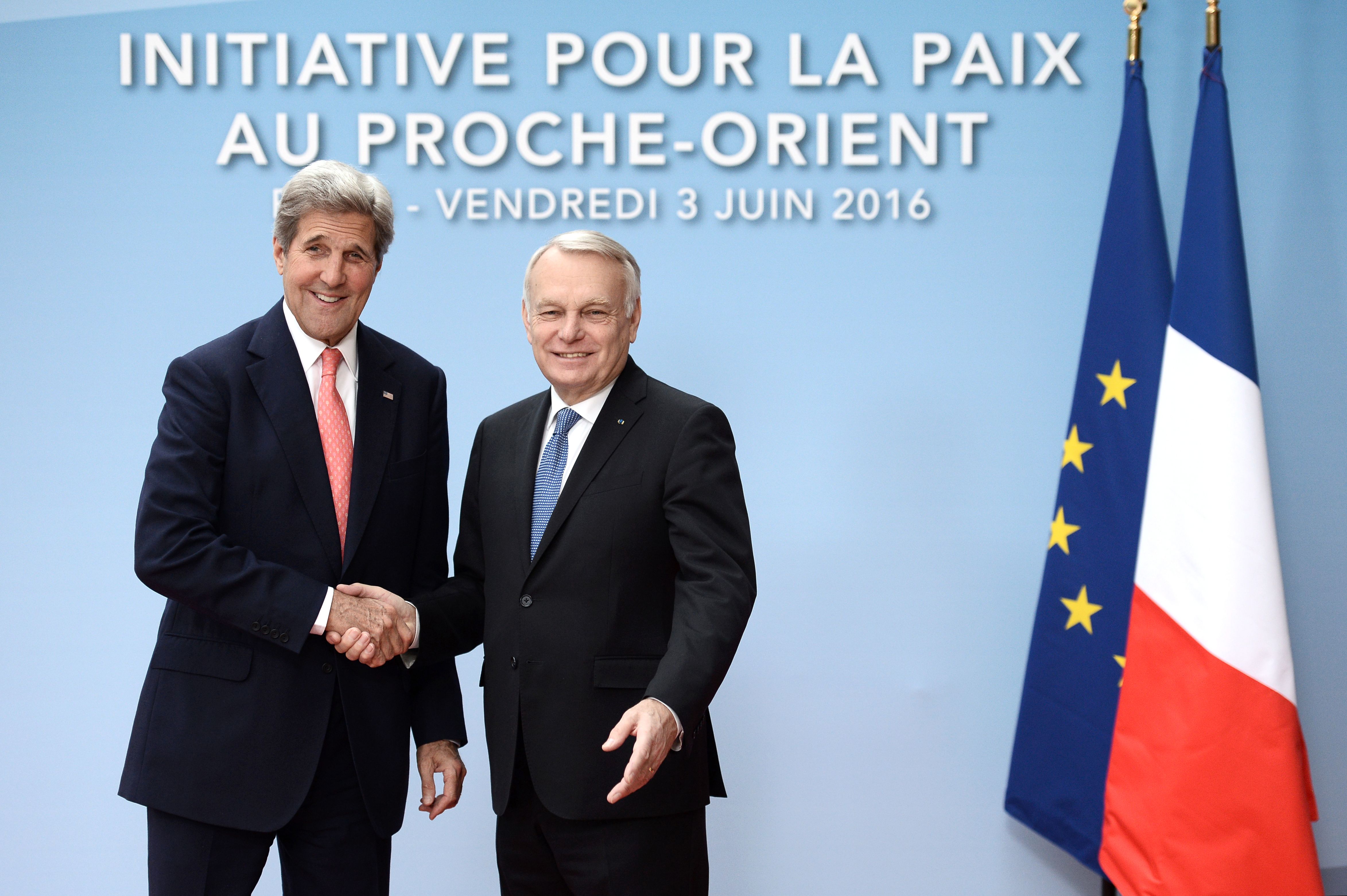 French Foreign minister Jean-Marc Ayrault (R) shakes hands with US Secretary of State John Kerry upon his arrival for an international and interministerial meeting in a bid to revive the Israeli-Palestinian peace process, in Paris, on June 3, 2016. France will host talks on the Israeli-Palestinian conflict that have received a chilly response from Washington, but diplomats say merely swinging the spotlight back onto the stalemate is a victory. Instead representatives of some 25 countries, as well as the United Nations, European Union and Arab League, will try and lay the ground for a fully-fledged peace conference to be held by the end of the year.