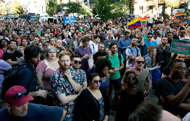 People gather outside of the Stonewall Inn as a vigil is held following the massacre that occurred at a gay Orlando nightclub early Sunday morning. 