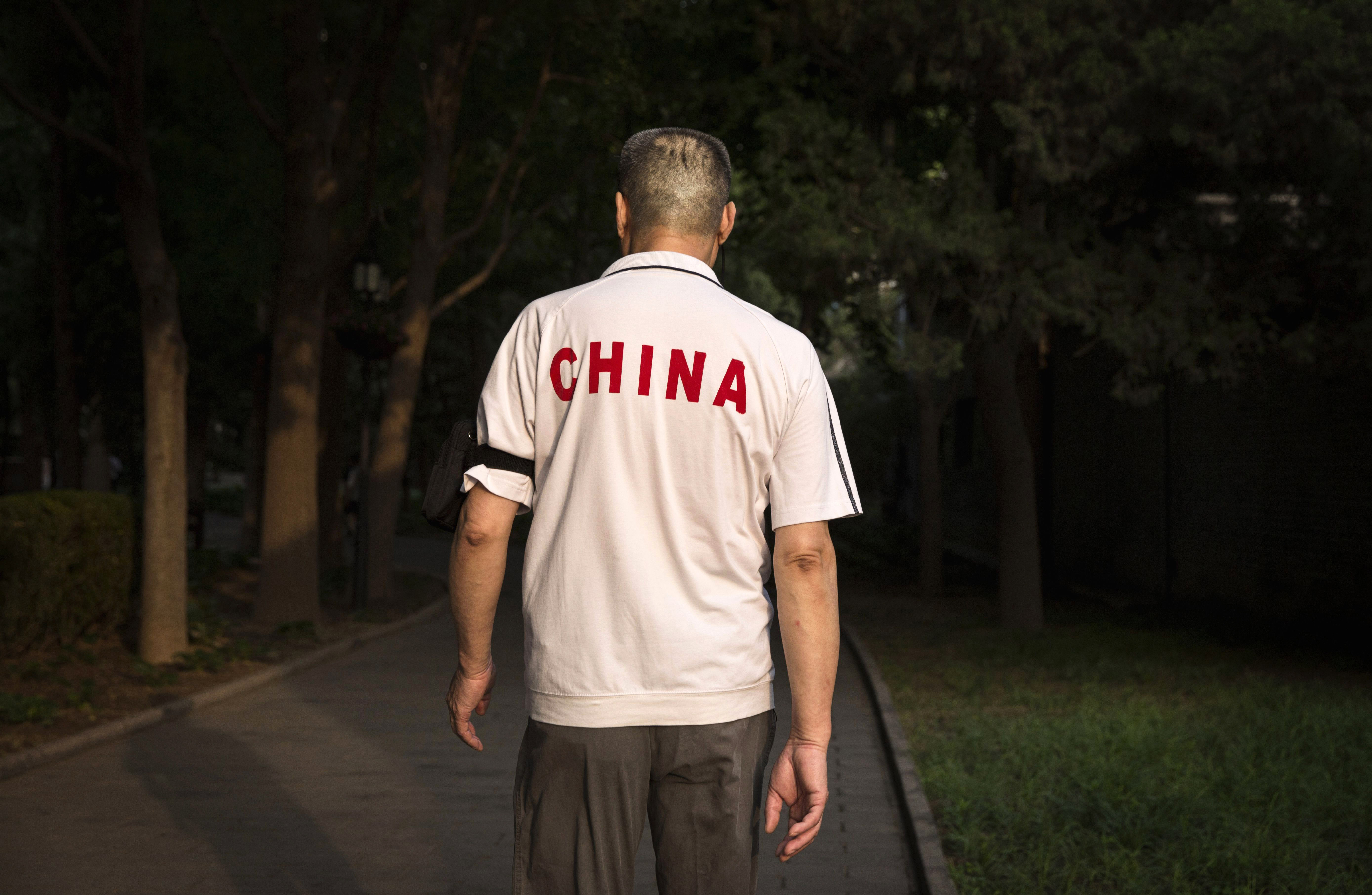 BEIJING, CHINA - JUNE 11: A Chinese man walks at Ritan Park on June 11, 2016 in Beijing, China. Ritan, meaning 'sun altar', is among the oldest parks in Beijing, built in the early 1500s during the Ming dynasty for the emperor to make sacrifices to the sun. Less than half a kilometer square, Ritan these days is considered an oasis of green space in a sprawling city of skyscrapers, notorious air pollution, and a population of over 20 million people. Most Chinese live in small apartments with no access to gardens, leaving parks as a welcome haven for people, especially the elderly, to exercise, socialize, or enjoy a degree of privacy. The average day at Ritan is a showcase of conventional routines such as jogging, dancing, and martial arts, mixed with the assortment of odd activities -- including 'voice exercises' and back-scratching on trees -- that are known to be unique staples of Beijing park life.