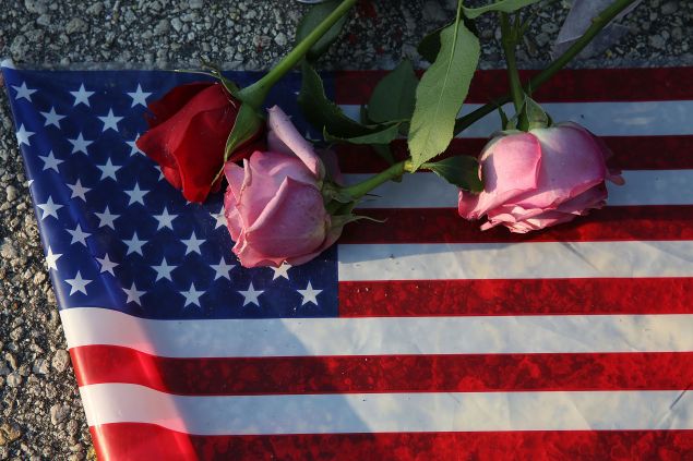 Flowers and an American flag are seen on the ground near the Pulse Nightclub where Omar Mateen allegedly killed at least 50 people on June 13, 2016 in Orlando, Florida.