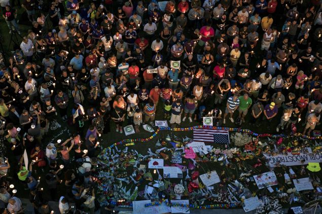 Mourners hold candles while observing a moment of silence during a vigil outside the Dr. Phillips Center for the Performing Arts for the mass shooting victims at the Pulse nightclub June 13, 2016 in Orlando, Florida.