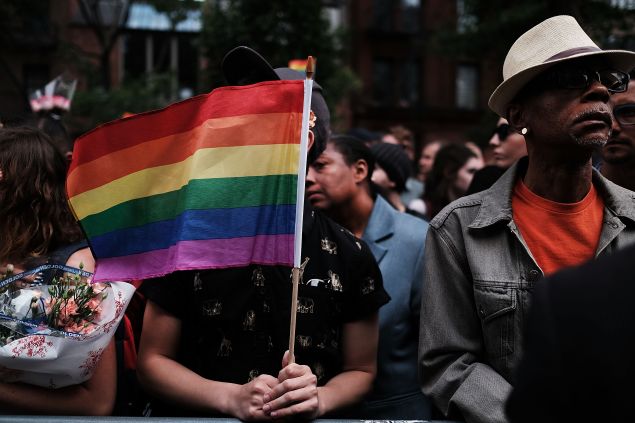Hundreds of people listen to speakers at a memorial gathering for those killed in Orlando in front of the iconic New York City gay and lesbian bar The Stonewall Inn on June 13, 2016 in New York City. An American-born man who had recently pledged allegiance to ISIS killed 50 people early Sunday at a gay nightclub in Orlando, Florida.
