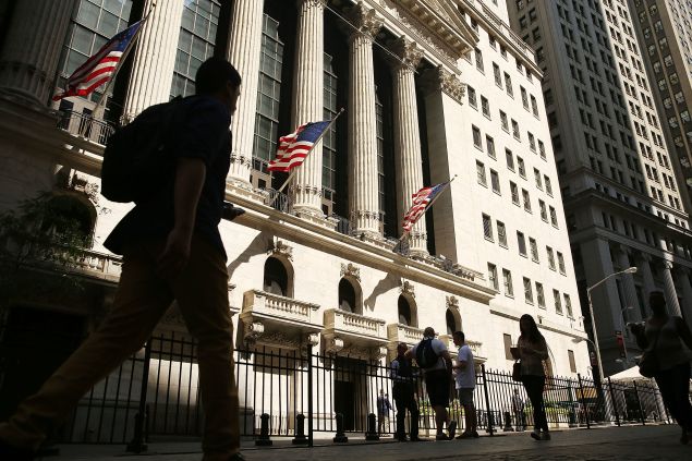 People walk by the NYSE following news of the Brexit.
