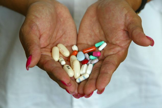 Alba Cerrato displays her cocktail of 14 different AIDS medications that she takes three times a day July 11, 2002 in Miami, Florida.