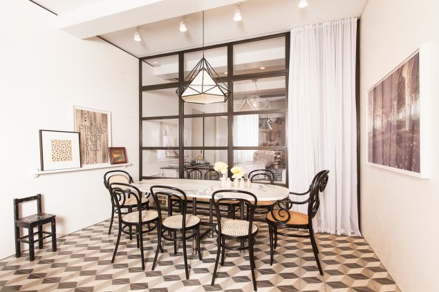 A marble table sits in front of the windowed wall of the bedroom