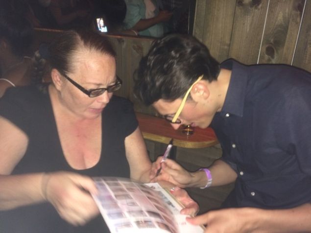Signing autographs.