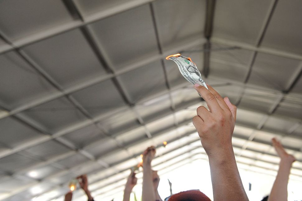 INDIO, CA - APRIL 18: Fans burn dollar bills during the King Khan and the Shrines performance at day 3 of the Coachella Valley Music & Art Festival 2010 held at The Empire Polo Club on April 18, 2010 in Indio, California.