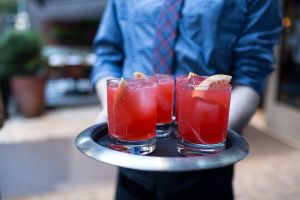 A waiter brings out the Perche Aspettare— Campari, fresh grapefruit juice and prosecco—at the party for "Spritz: Italy’s Most Iconic Aperitivo Cocktail, with Recipes” at Sessanta.