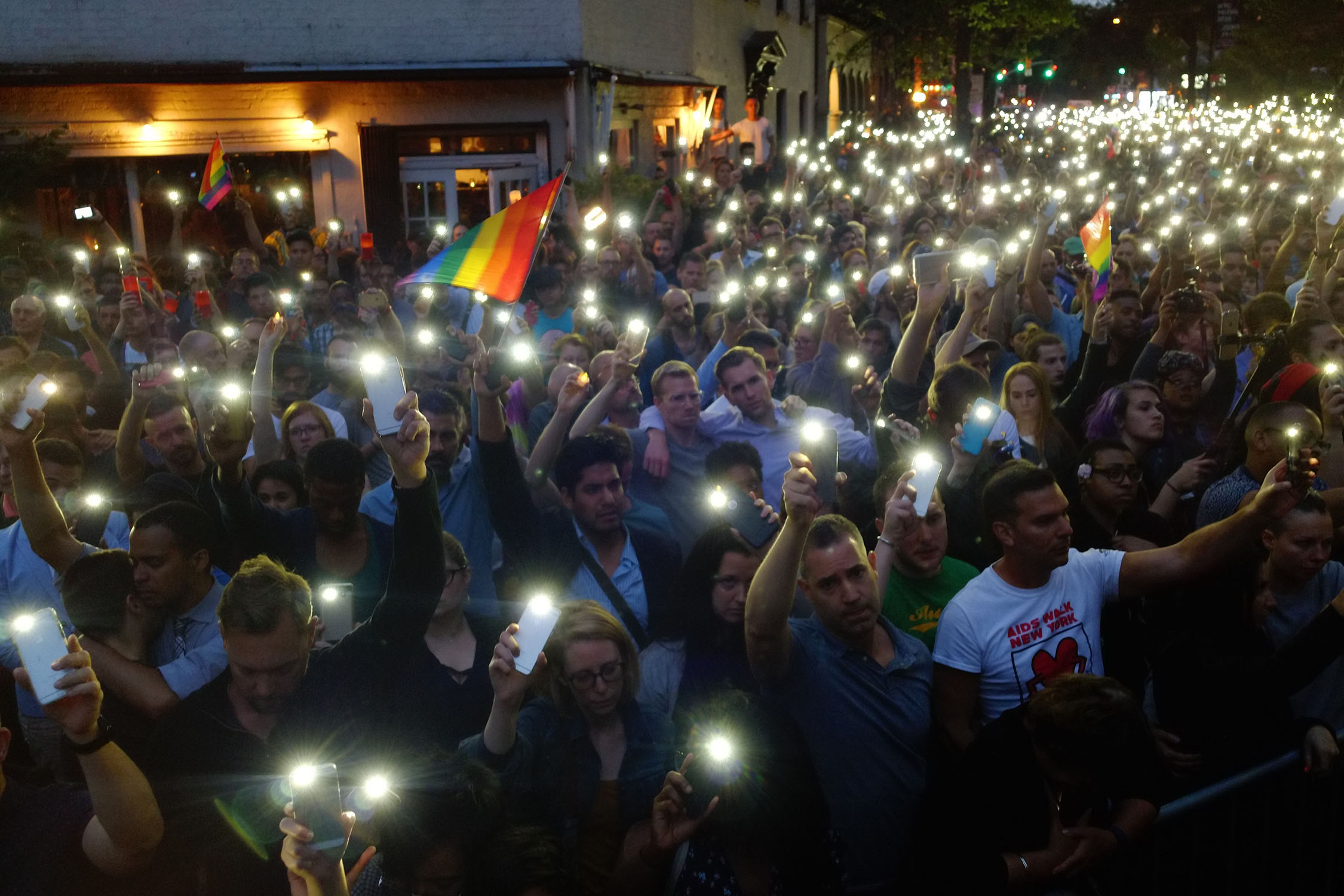 Outside Stonewall, people hold lit cell phones as the names of those killed in Orlando are read.