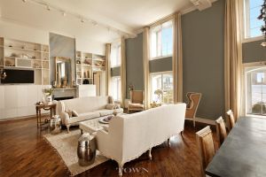 The great room has double-height ceiling and views of the Hudson River.