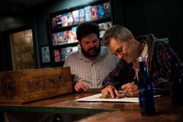 Director Jonathan Demme signs memorabilia under the watchful eye of Nitehawk technical director and programmer Max Cavanaugh at a recent 35mm screening of Demme's "Caged Heat"