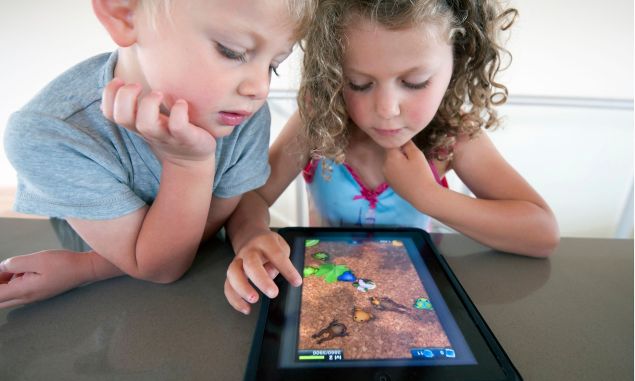 These kids may be engrossed in their iPad, but a new book says the tablet is harmful to their developing brains.