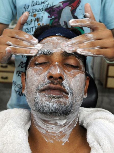 A man indulges in a facial massage at a beauty salon