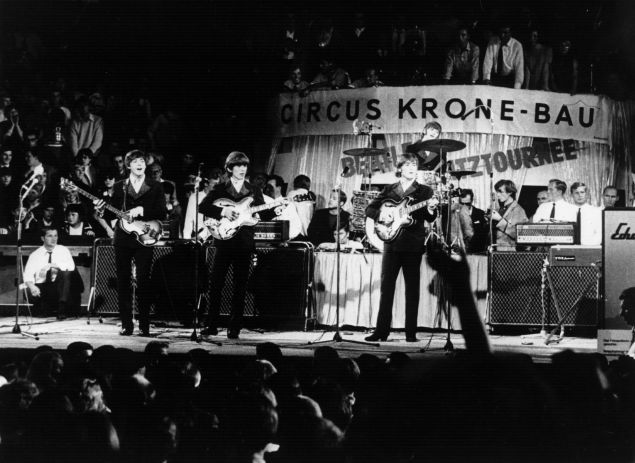 The Beatles performing on stage before thousands at the Circus Krone Bau in Munich.