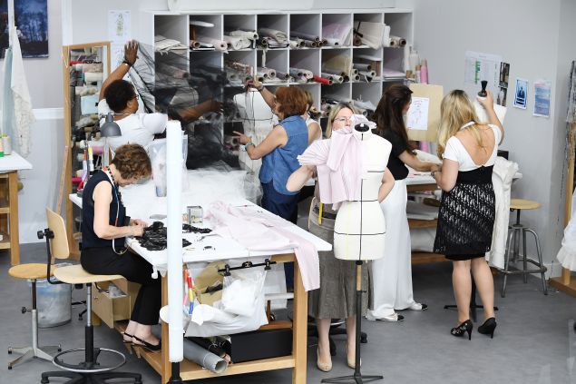 The petite mains at work, in front of the runway