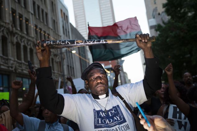 A man holds a bat reading "Black Power" during a protest in Dallas, Texas.