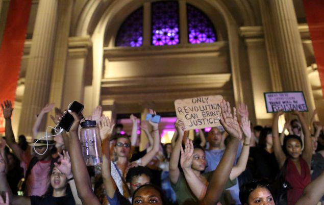 Activists have their hands up in front of The Metropolitan Museum of Art as they march up 5th Ave.