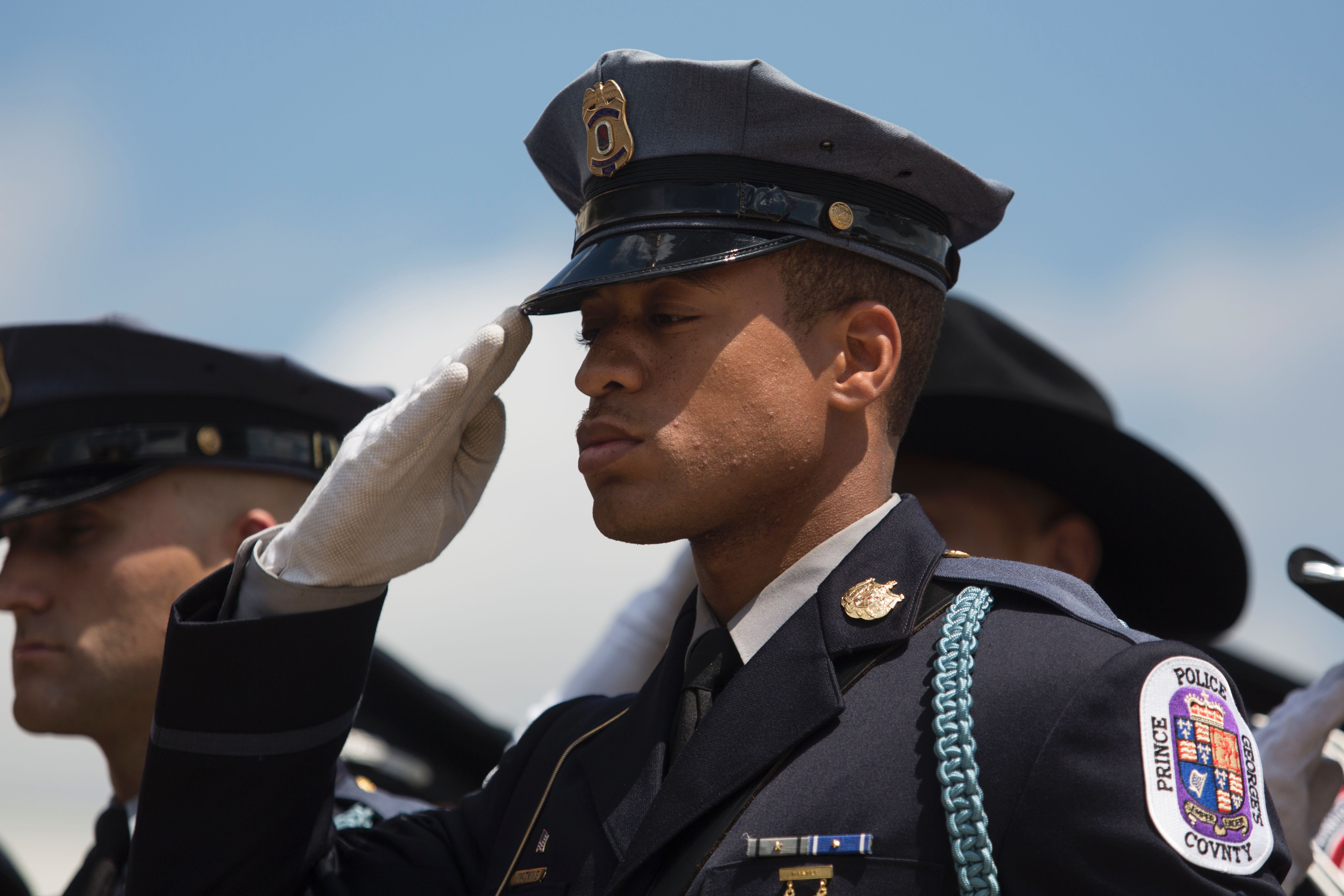 Police officers salutes the casket of Officer Brent Thompson as it is escorted out of the memorial service in Dallas on July 13, 2016. Officer Thompson and four others were killed July 7 by a gunman during a protest in downtown Dallas.