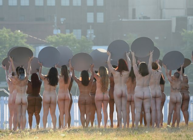 Women holding mirrors participate in a photo shoot by artist Spencer Tunick in his latest large-scale art installation: Everything She Says Means Everything," across from site of the Republican National Convention in Cleveland July 17, 2016 where naked women will stand facing the Quicken Loans Arena holding large, round mirrors. / AFP / TIMOTHY A. CLARY / RESTRICTED TO EDITORIAL USE - MANDATORY MENTION OF THE ARTIST UPON PUBLICATION - TO ILLUSTRATE THE EVENT AS SPECIFIED IN THE CAPTION - NO CLOSE UP SHOTS TO BE REPRODUCED OF INDIVIDUALS INVOLVED IN THE INSTALLATION