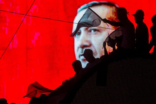 ANKARA, TURKEY - JULY 17: People wave Turkish flags in front of an electronic billboard displaying the face of President Recep Tayyip Erdogan at a rally on the streets of Kizilay Square in reaction to the failed military coup on July 17, 2016 in Ankara, Turkey. Clean up operations are continuing in the aftermath of Friday's failed military coup attempt which claimed the lives of more than 250 people. In raids across Turkey 6,000 people have been arrested in relation to the failed coup including high-ranking soldiers and judges, Turkey's Justice Minister Bekir Bozdag has said.