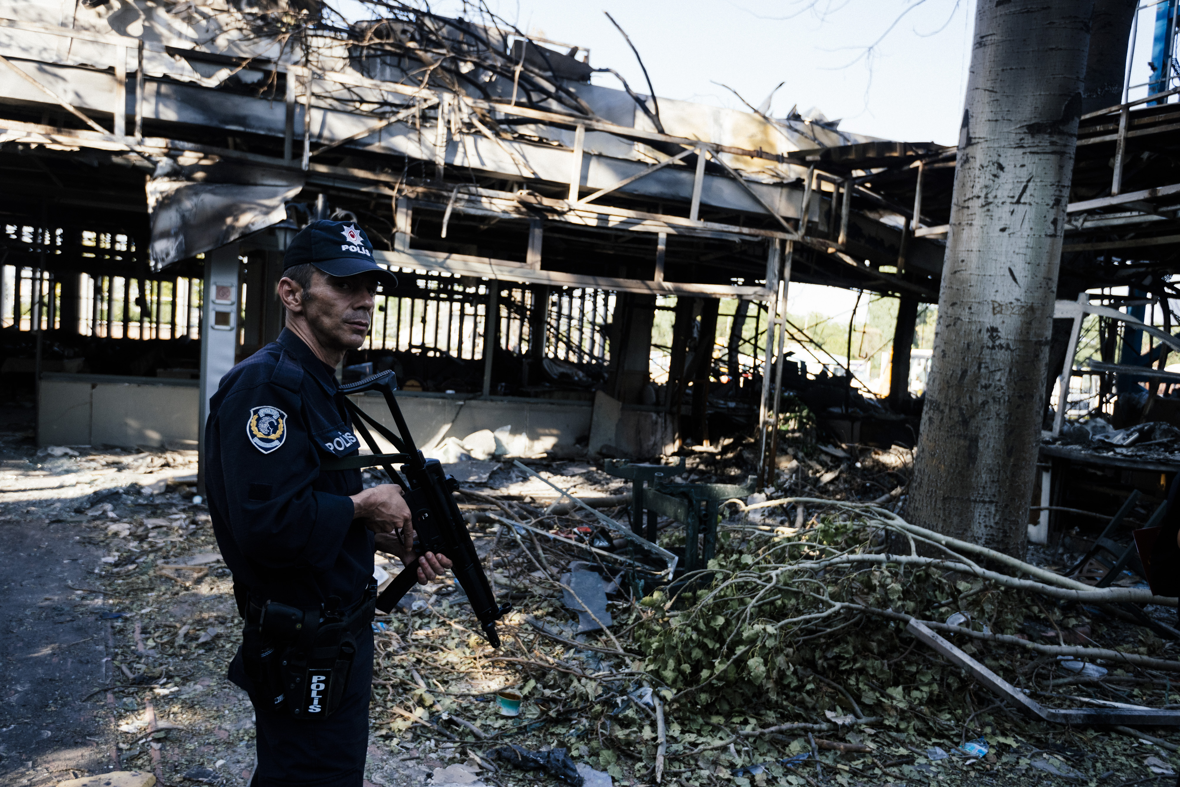 An armed Turkish police officer stands guard near debris at the damaged Ankara police headquarters on July 19, 2016, after it was bombed during the failed July 15 coup attempt.