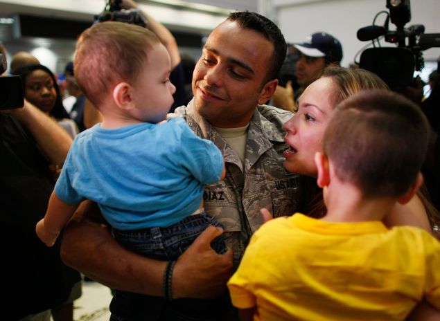 MIAMI - AUGUST 13: U.S. Air Force E-4 Senior Airman Francisco Diaz (2L) from the 482nd Security Forces Squadron at Homestead Air Reserve Base greets his fiancee Jacqueline Vazquez (2R) and sons Haisan Diaz (L), 1, and Julian Diaz, 3, as he arrives home after a six-month deployment to Iraq at the Miami International Airport August 13, 2008 in Miami, Florida.