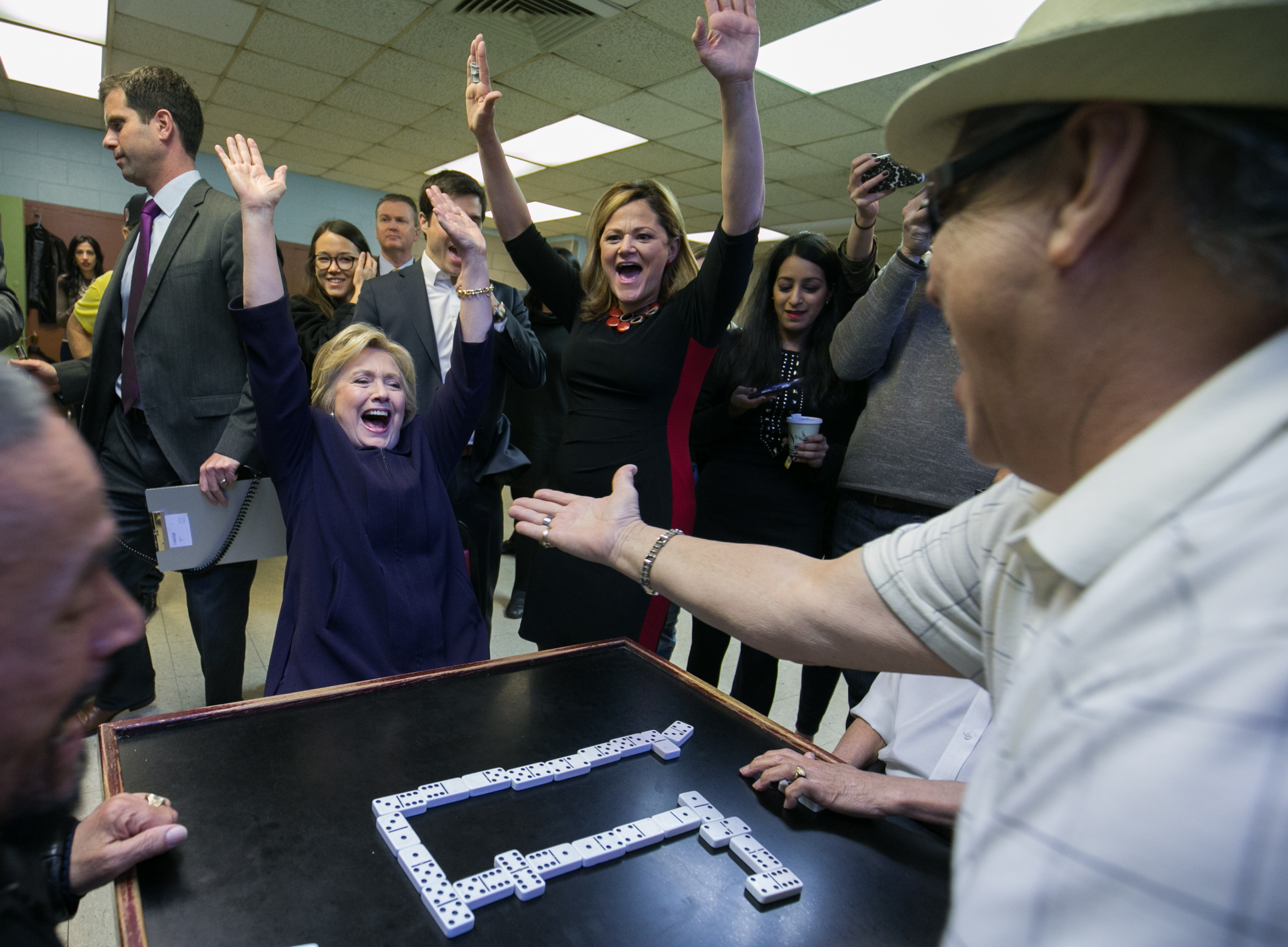 Hillary Clinton and Melissa Mark-Viverito cheer after the candidate wins a game of dominoes in an East Harlem housing project.