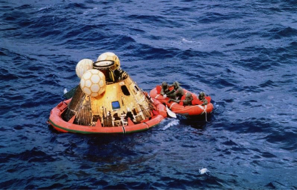 Apollo 11 crewmen await pickup by helicopter following splashdown on July 24, 1969.