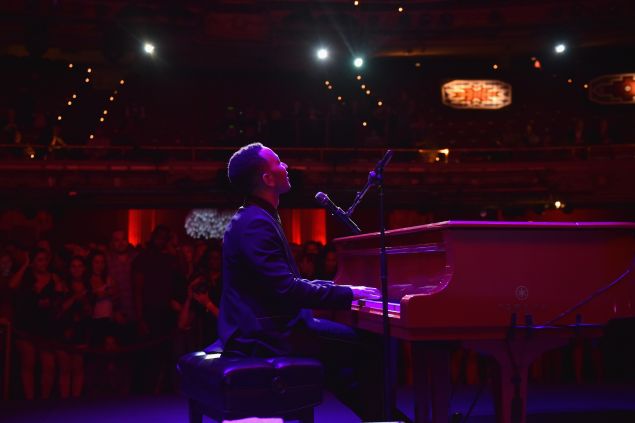 John Legend performing on stage at the Apollo Theater