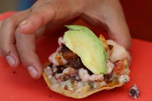 A lady from La Guerrerense of Mexico prepares a Tostada during the World Street Food Jamboree.