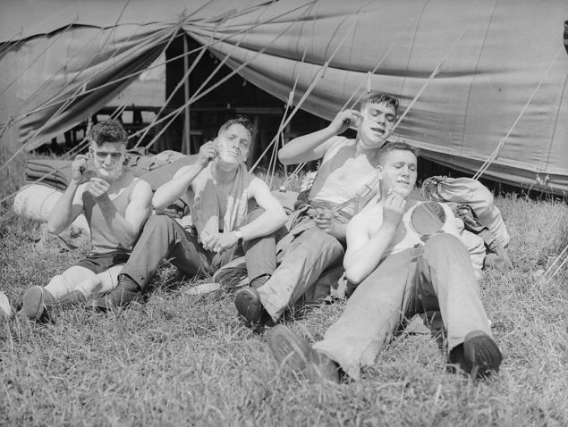 June 1935: Members of the 26th Armoured Car Company of the Territorial Army shaving during a camp in Cayton Bay.