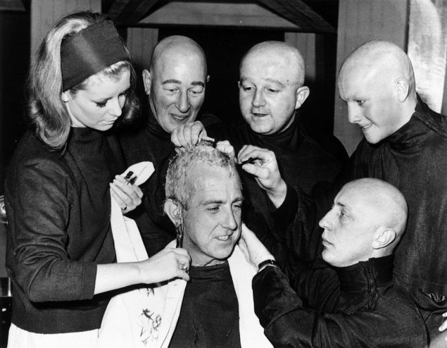 22nd October 1965: Hair stylist Joan Barrett shaves the head of actor David Freed, the last of the actors to be prepared for playing 'Teknix' in a Dr Who television special.