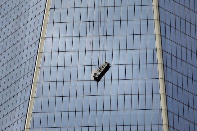 NEW YORK, NY - NOVEMBER 12: A scaffold carrying two workers hangs 69 floors up at 1 World Trade Center on November 12, 2014 in New York City. The workers were washing windows 69 floors up soon after 1 World Trade Center, the tallest building in the Western Hemisphere, opened.