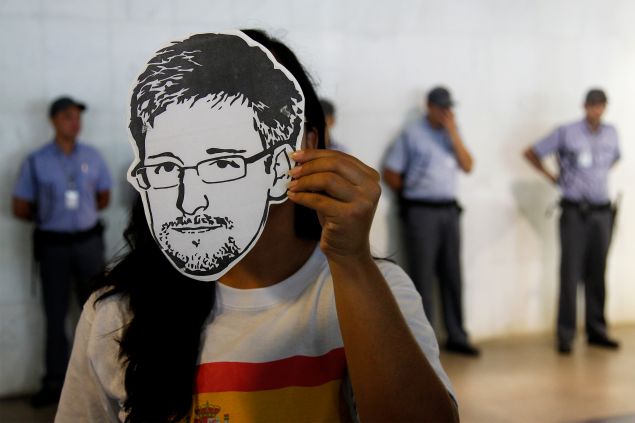 A member of the Avaaz online community organization wears a "Snowden" mask during the delivery at the the Itamaraty Foreign Ministry Palace of signatures supporting the granting of political asylum by Brazilian President Dilma Rousseff to Edward Snowden, in Brasilia, on February 13, 2014