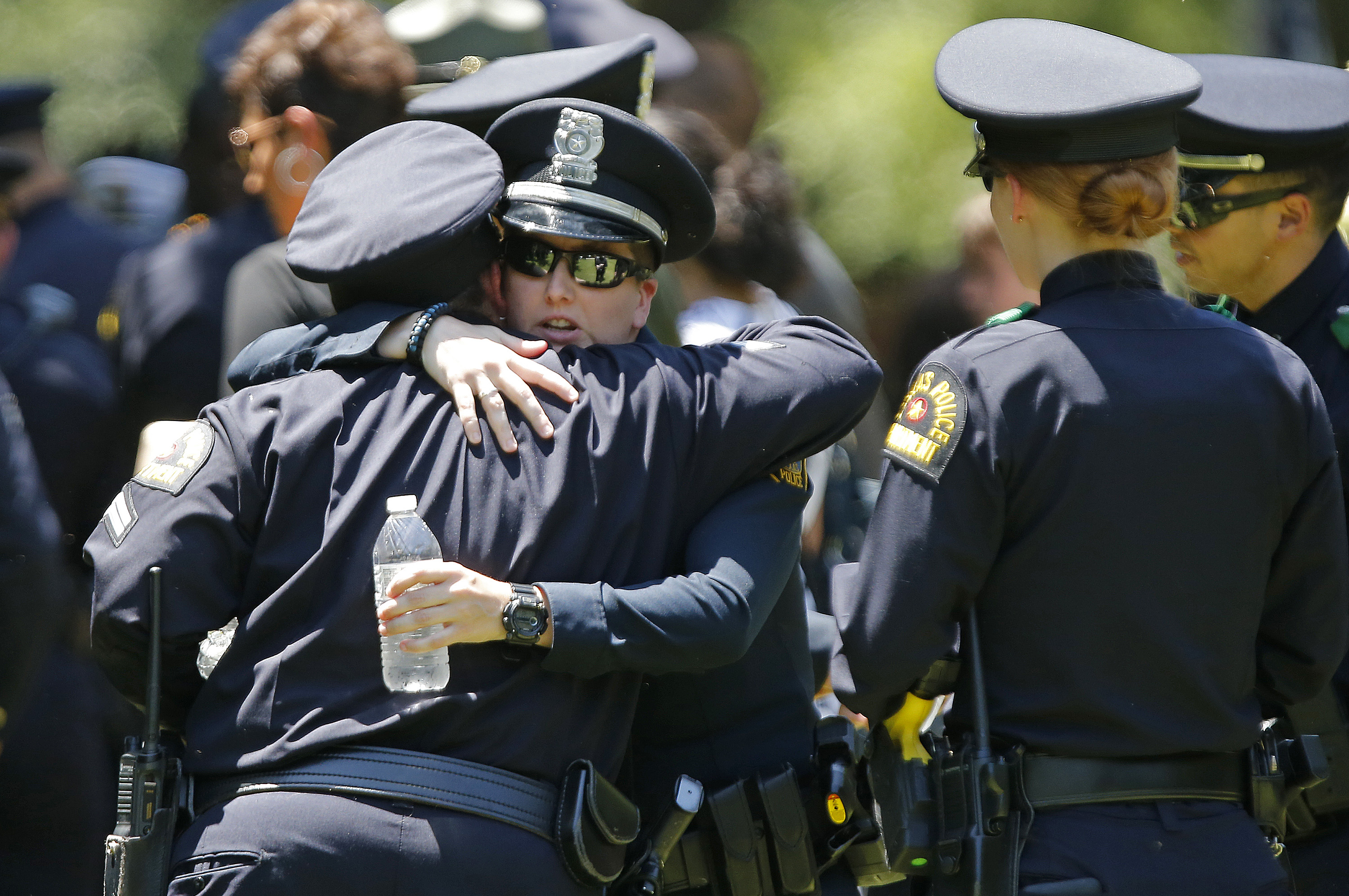 Dallas police officers comfort one another at the graveside service for Senior Corporal Lorne Ahrens on July 13, 2016