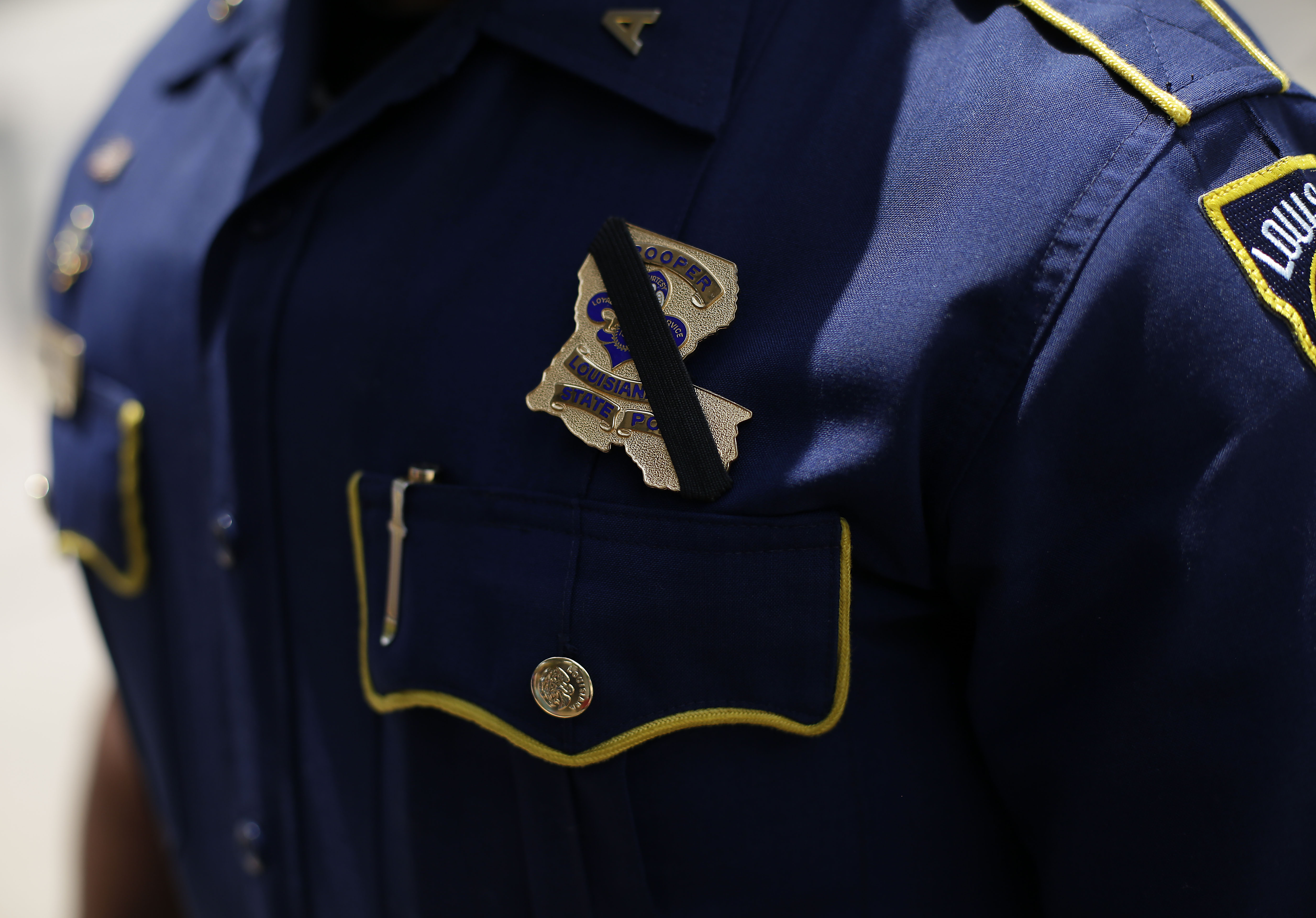 A black band is displayed around Louisiana State Police Officer Bryan Lee badge during a prayer vigil for Baton Rouge Police Officers Montrell Jackson, Matthew Gerald and East Baton Rouge Parish Sheriff Deputy Brad Garafola at the North Boulevard Town Square July 21, 2016 in Baton Rouge, Louisiana.
