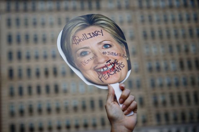 A supporter of former Democratic presidential candidate Bernie Sanders holds a sign against Hillary Clinton's nomination at a protest during the 2016 Democratic National Convention on July 27, 2016 in Philadelphia, Pennsylvania. / AFP / Patrick T. Fallon