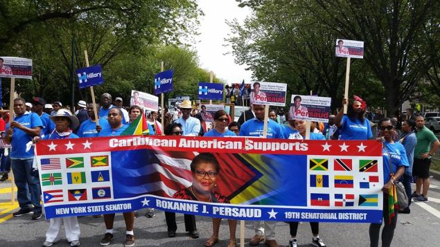 Supporters carry a banner for State Senator Roxanne Persaud.