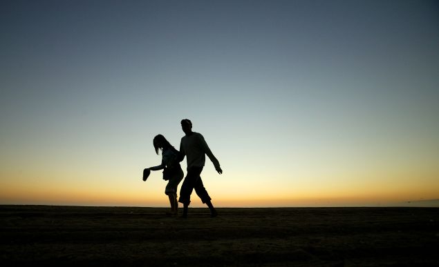 A couple walk along the beach in Santa Monica, California.