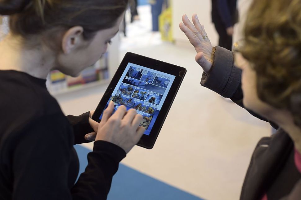 Visitors use an E-Book reader during the 35th edition of the Paris Book Fair.