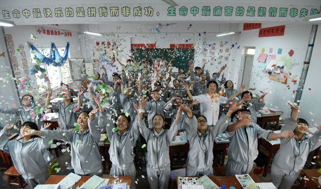 Senior high students cast shredded paper to release stress before the college entrance exams at a high school in Handan, north China's Hebei province
